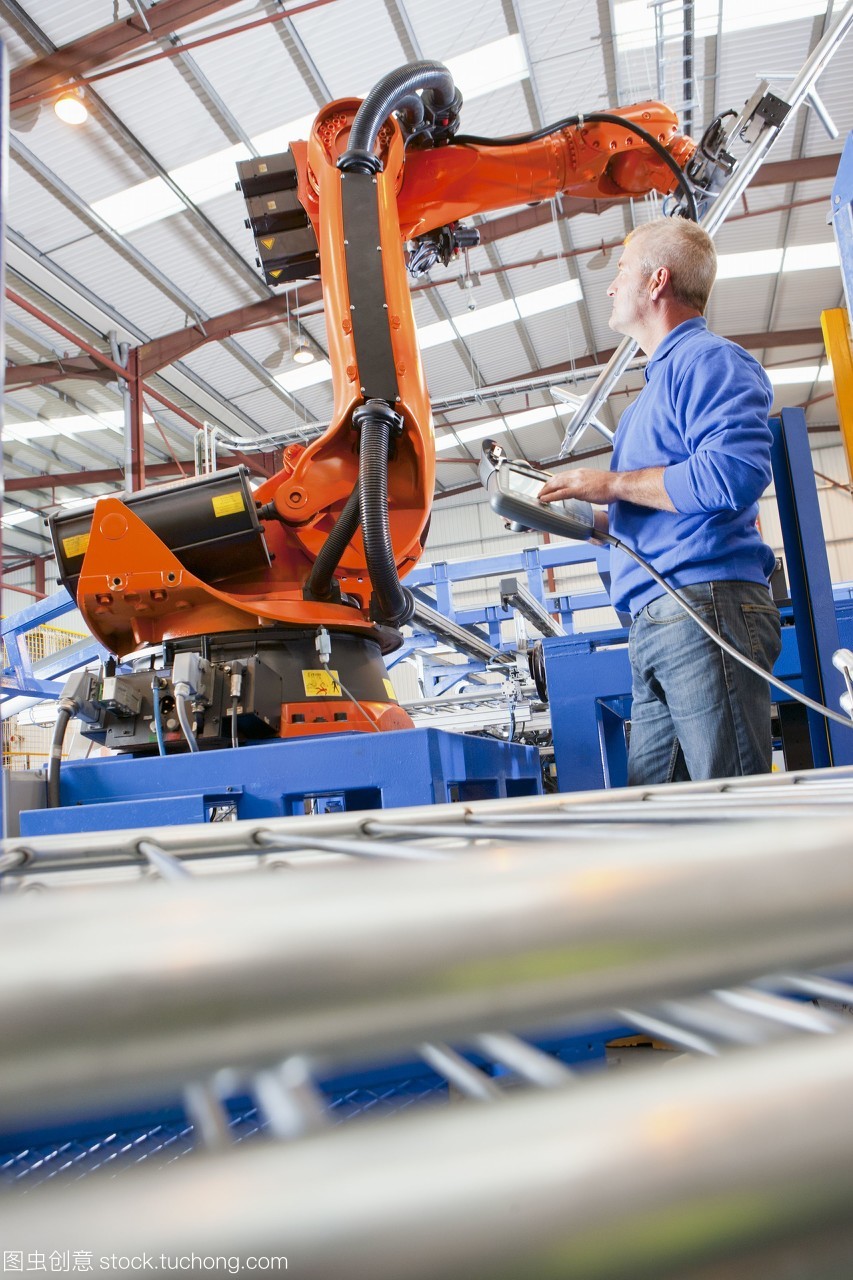 工人在制造工廠的生產線上控制機械吊裝